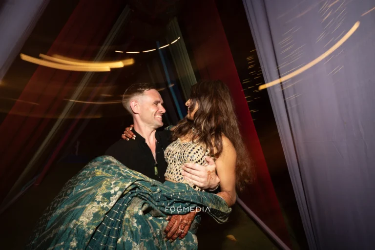 David lifting Salonee off the floor at the Sangeet, light streaking behind them