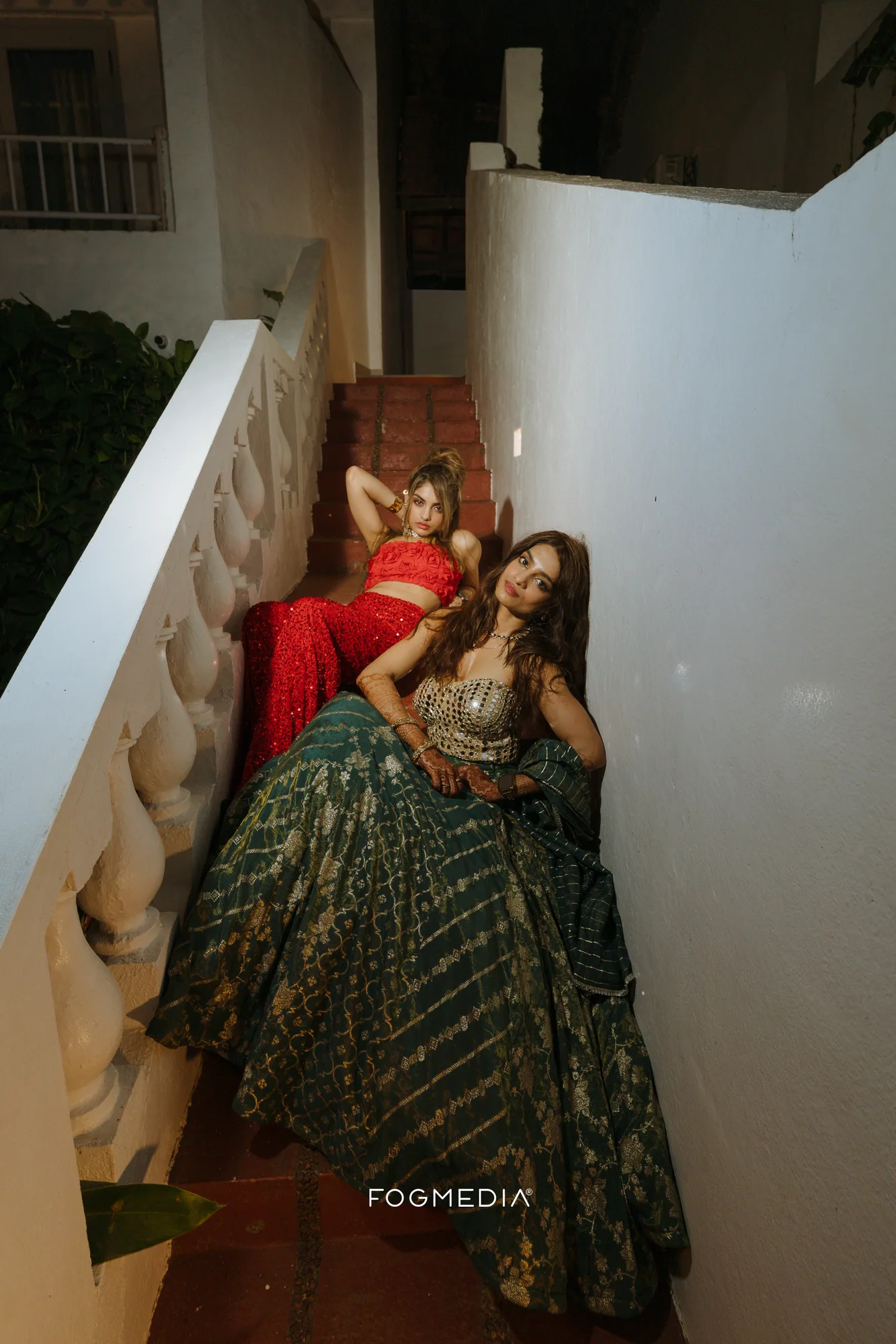 Salonee in a green and gold lehenga on the resort staircase at Prainha during the Sangeet