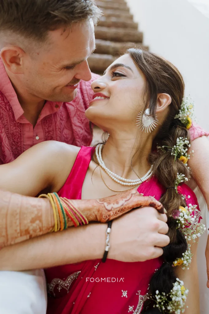 Gypsophila and yellow flowers braided through Salonee's hair, stacked glass bangles and set mehendi on her hand